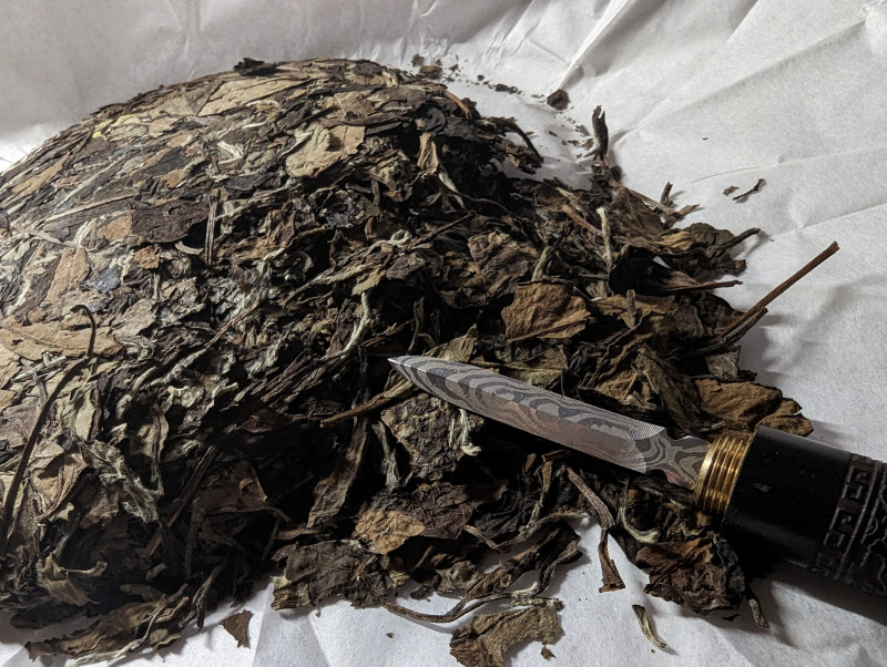ausgepackter Tee Fladen mit aufgebrochenen Blättern 