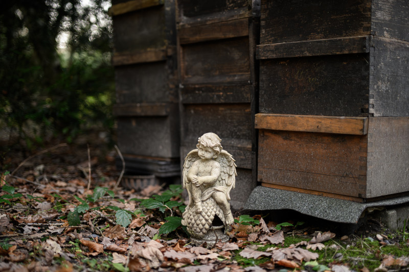 Kleiner Engel bewacht Bienenkörbe auf dem Friedhof. 