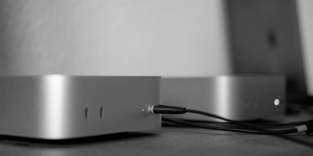 2 × Mac mini: Vorne der von meinem Arbeitgeber mit Headset über 3,5mm Klinke angeschlossen. Und hinten ist mein privater.