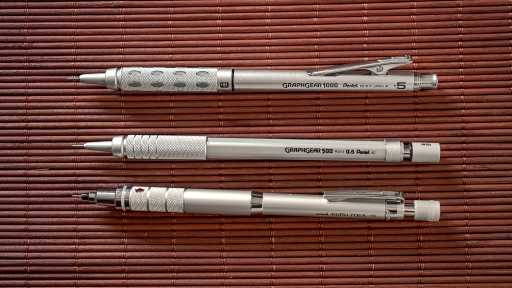 Drei Druckbleistifte auf einer Matte übereinander angeordnet. v.o.n.u. Pentel Graphgear 1000, Pentel Graphgear 500, uni-ball Kuru Toga